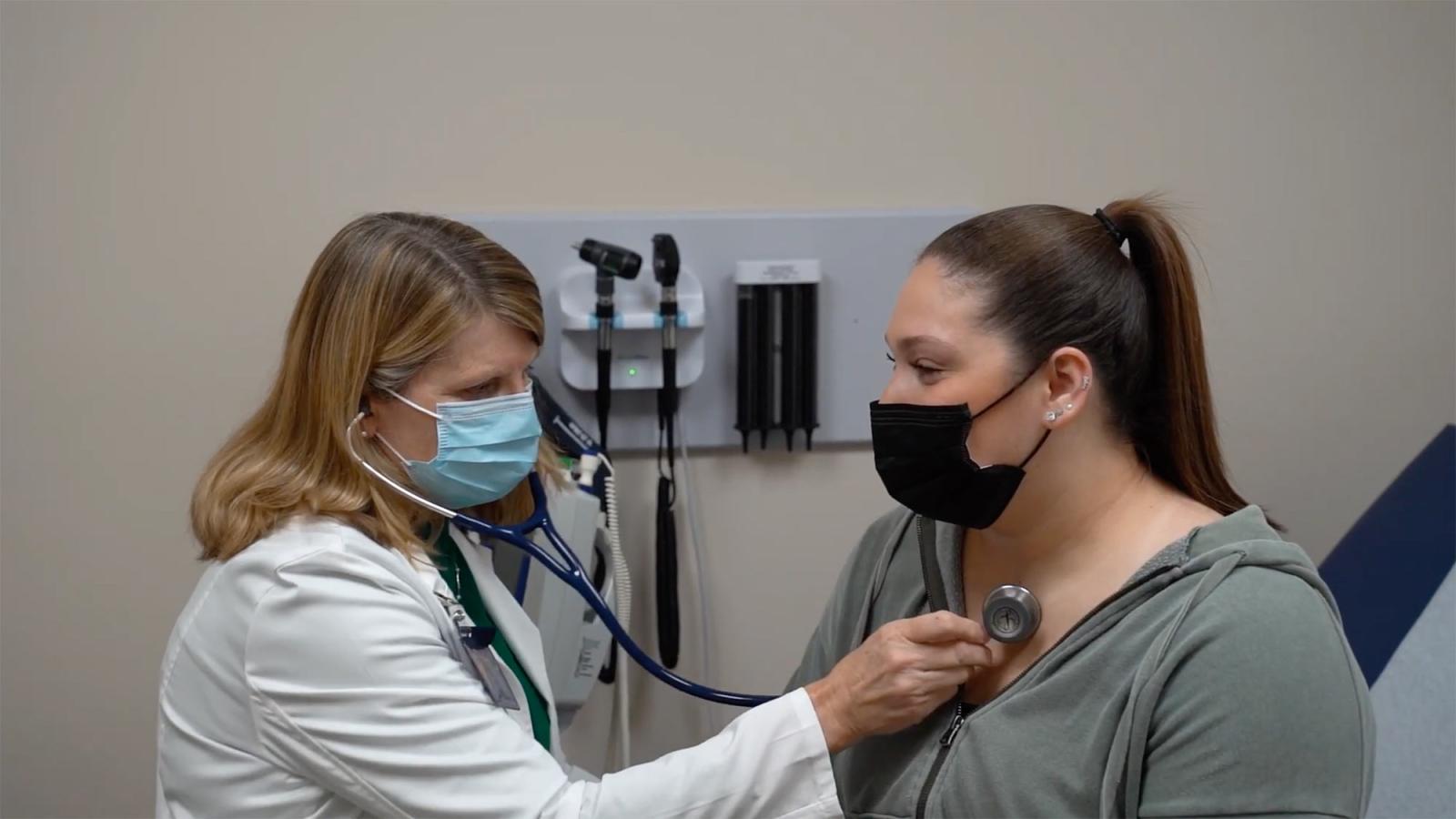 Student being helped by a staff member at the University Health Care Center.