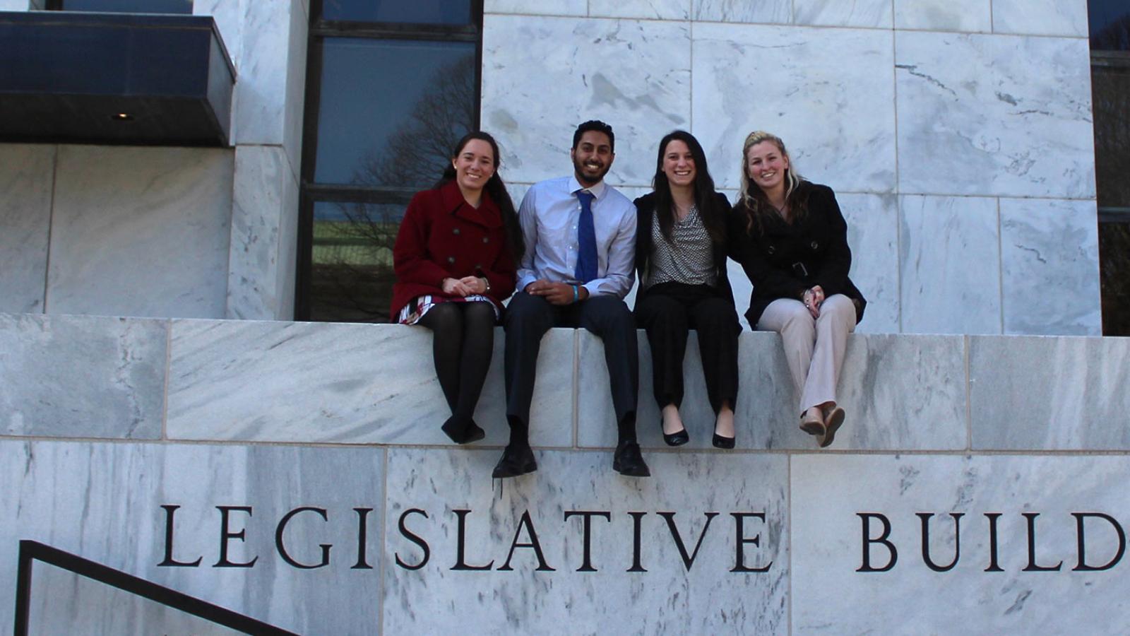 students sitting on wall of legislative building