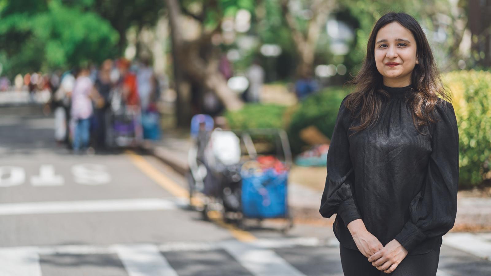 Rashmi Sharma wearing all black smiles at the camera 