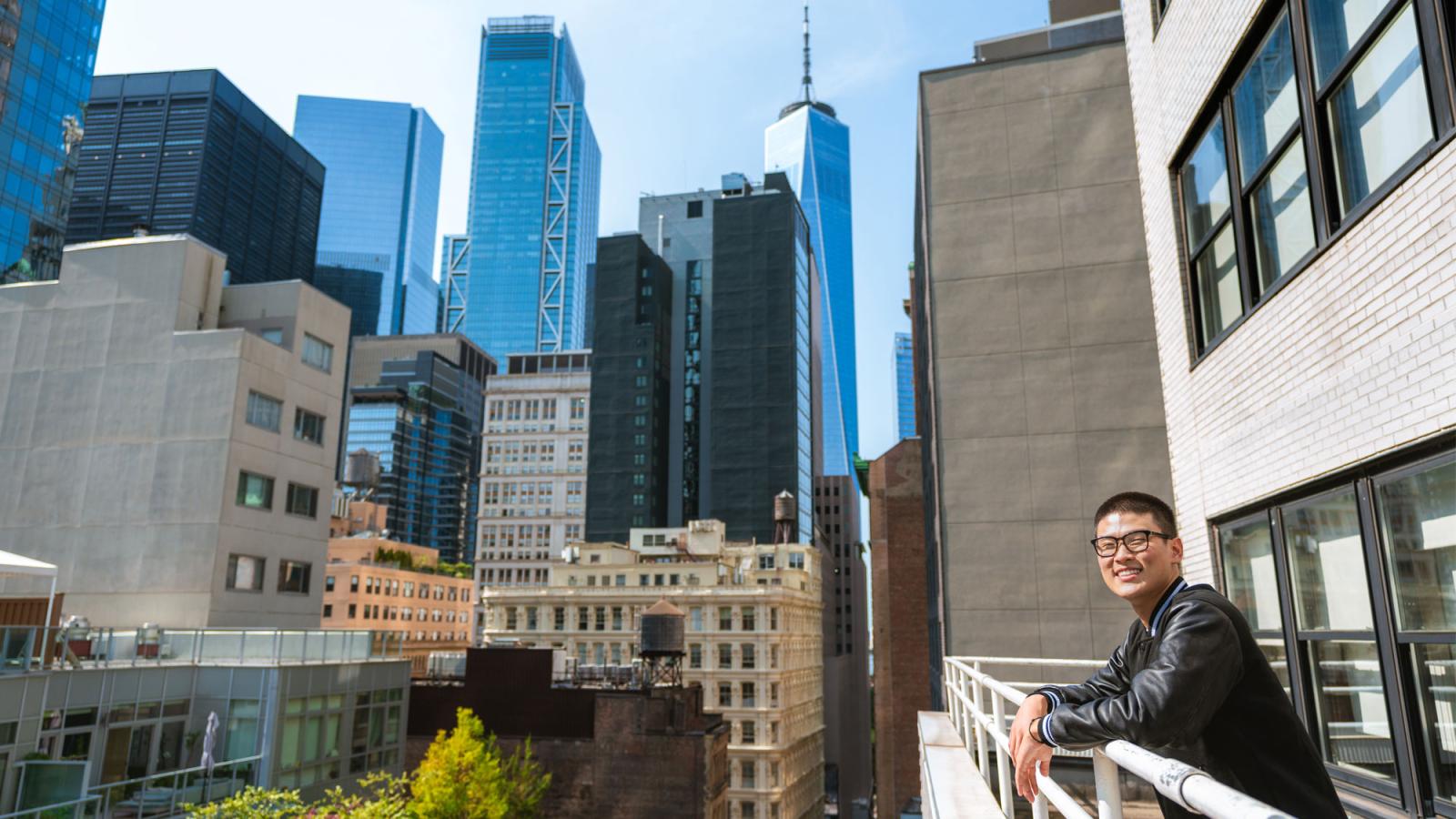 young man on rooftop smiling at the camera