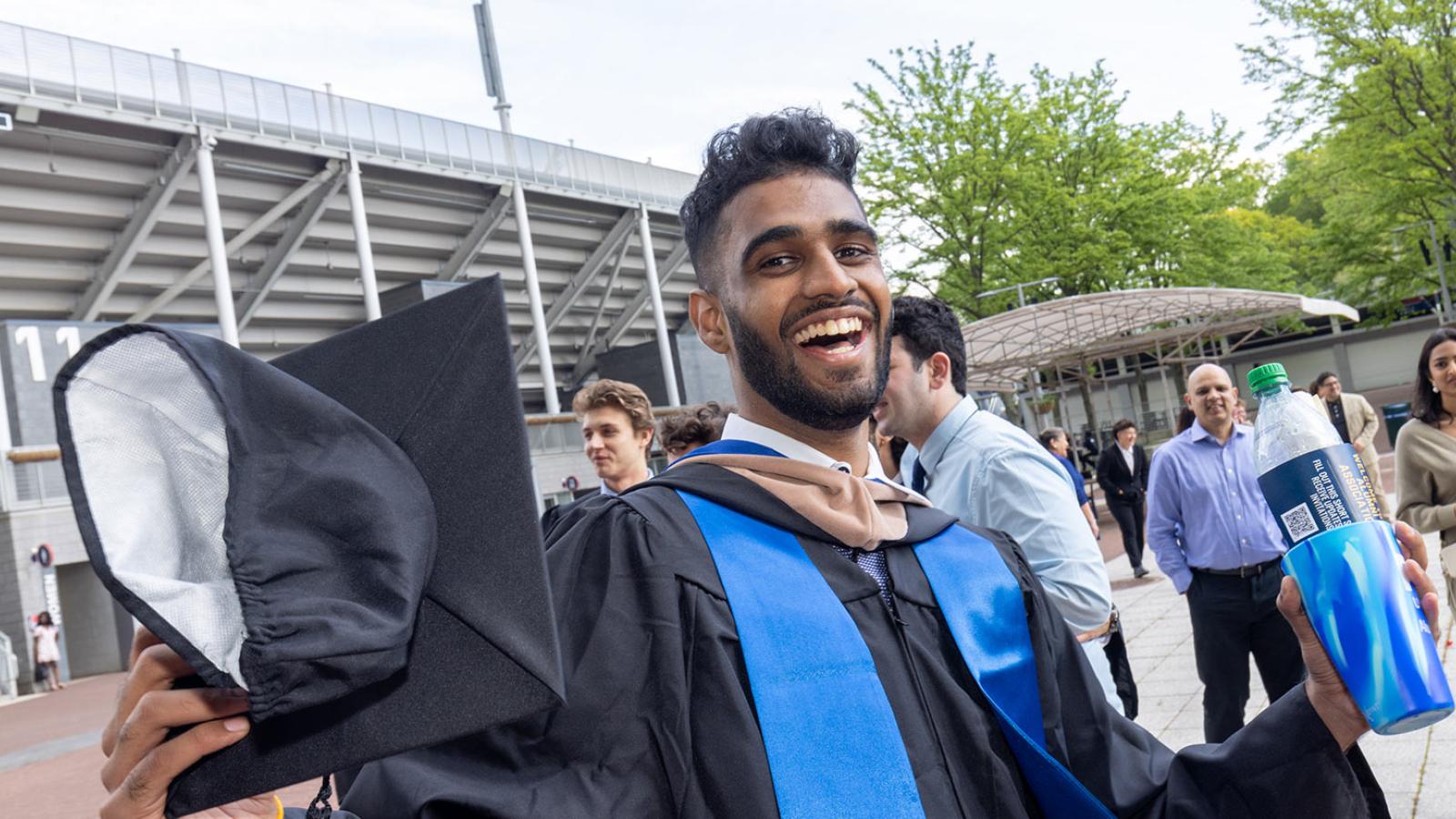 Pace student celebrating his commencement, smiling at the camera.