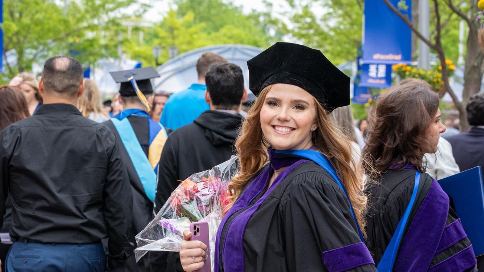 Student celebrating their Commencement and smiling at the camera.