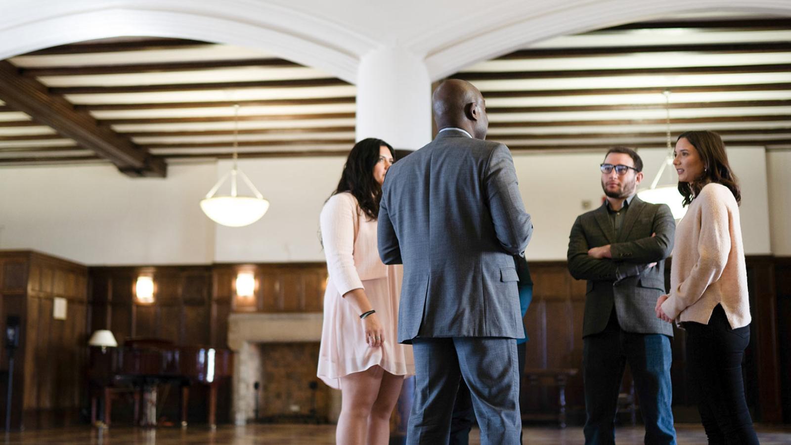 4 people having a conversation in the lobby of a building