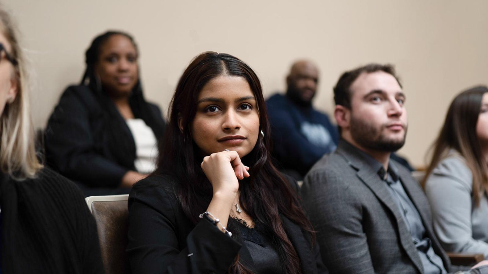 Law students sitting in a classroom listening to their professor.