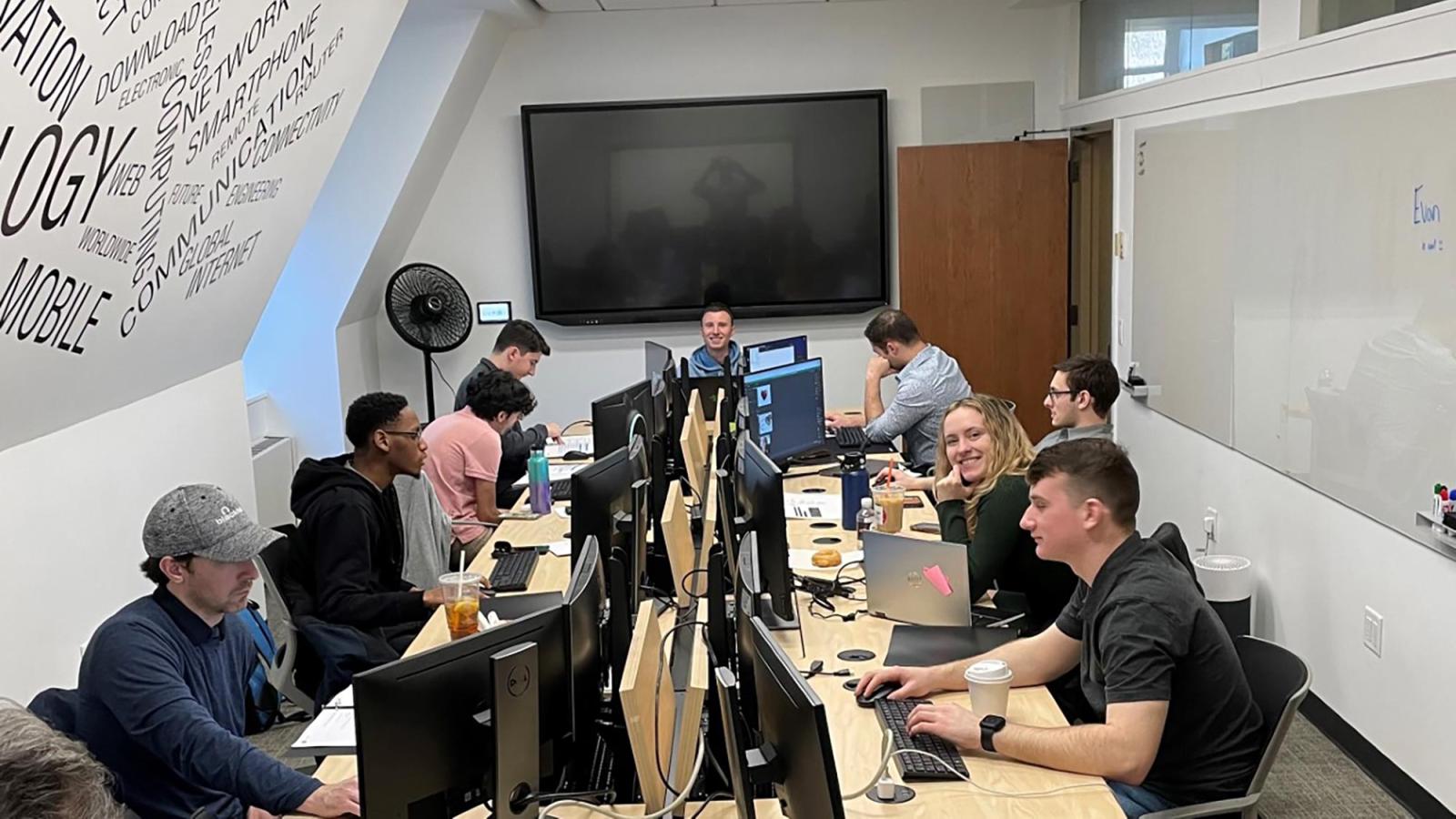 Seidenberg students gathered around a long table in hacking competition