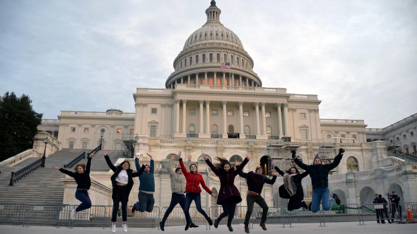 Group of Pace University economics students on the Fiscal Challenge Team jumping in front of the White House