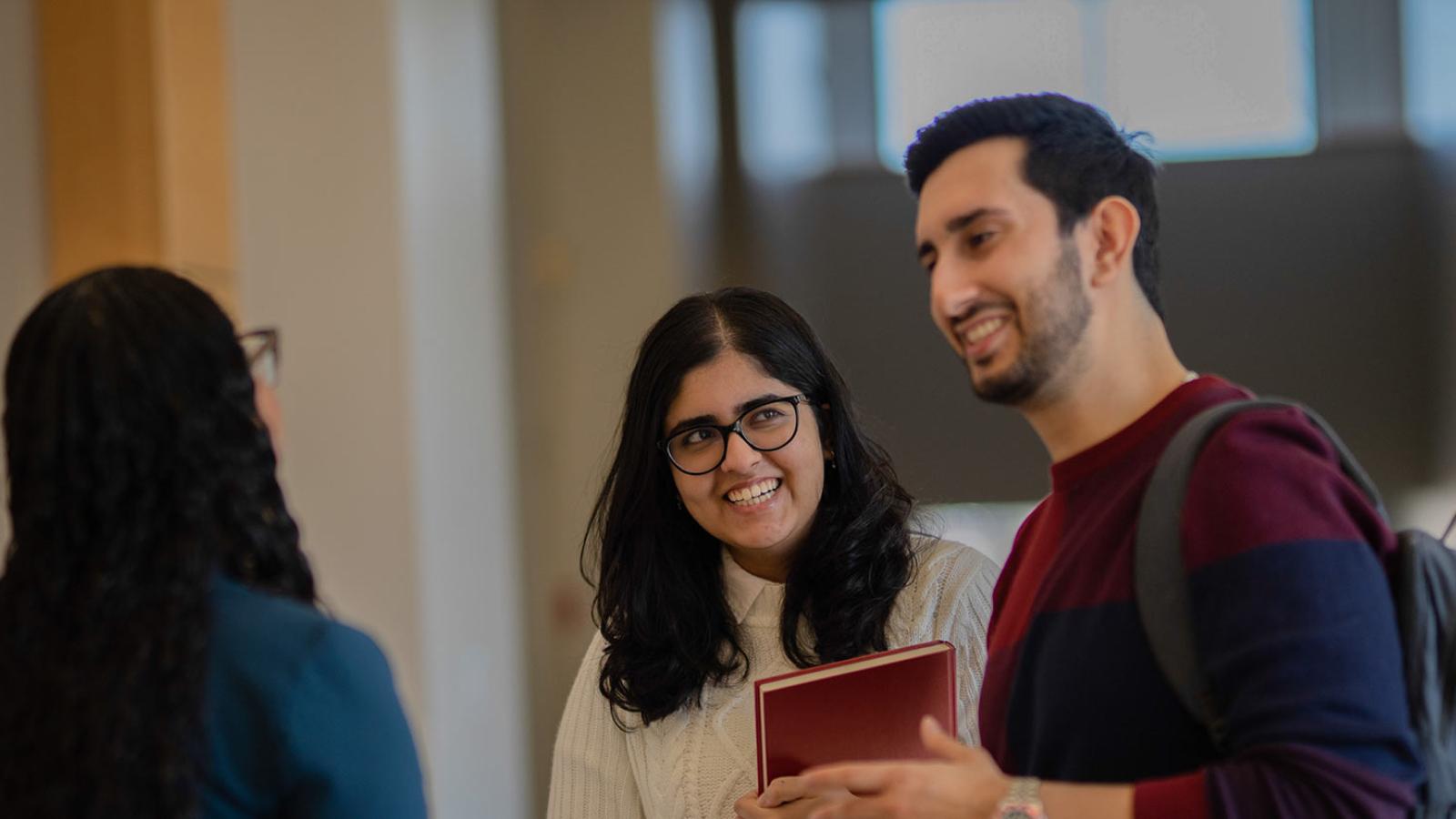 Group of students talking and laughing at the Elisabeth Haub School of Law 