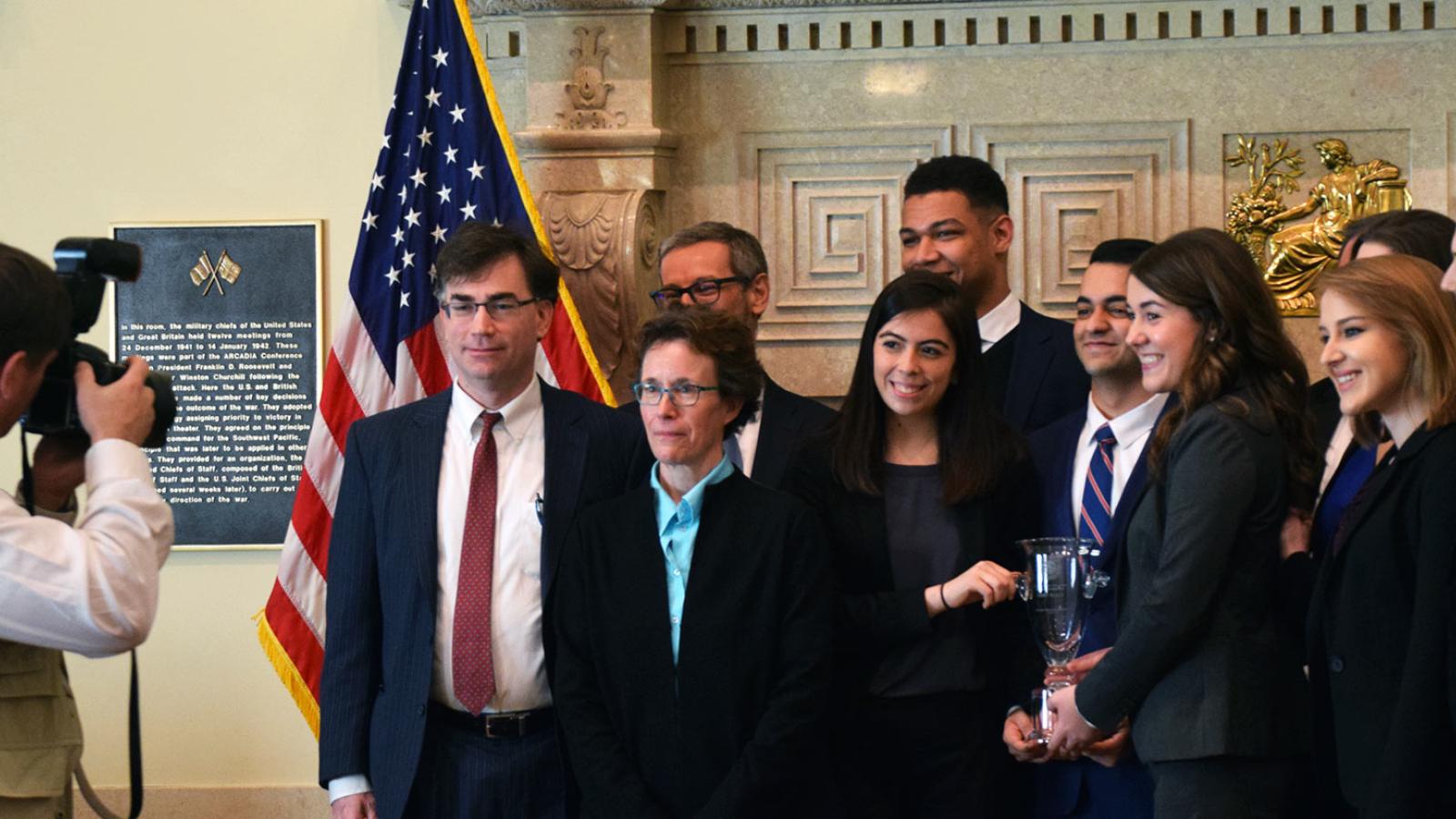 Group of Pace University economics students on the Federal Reserve Challenge Team holding trophy