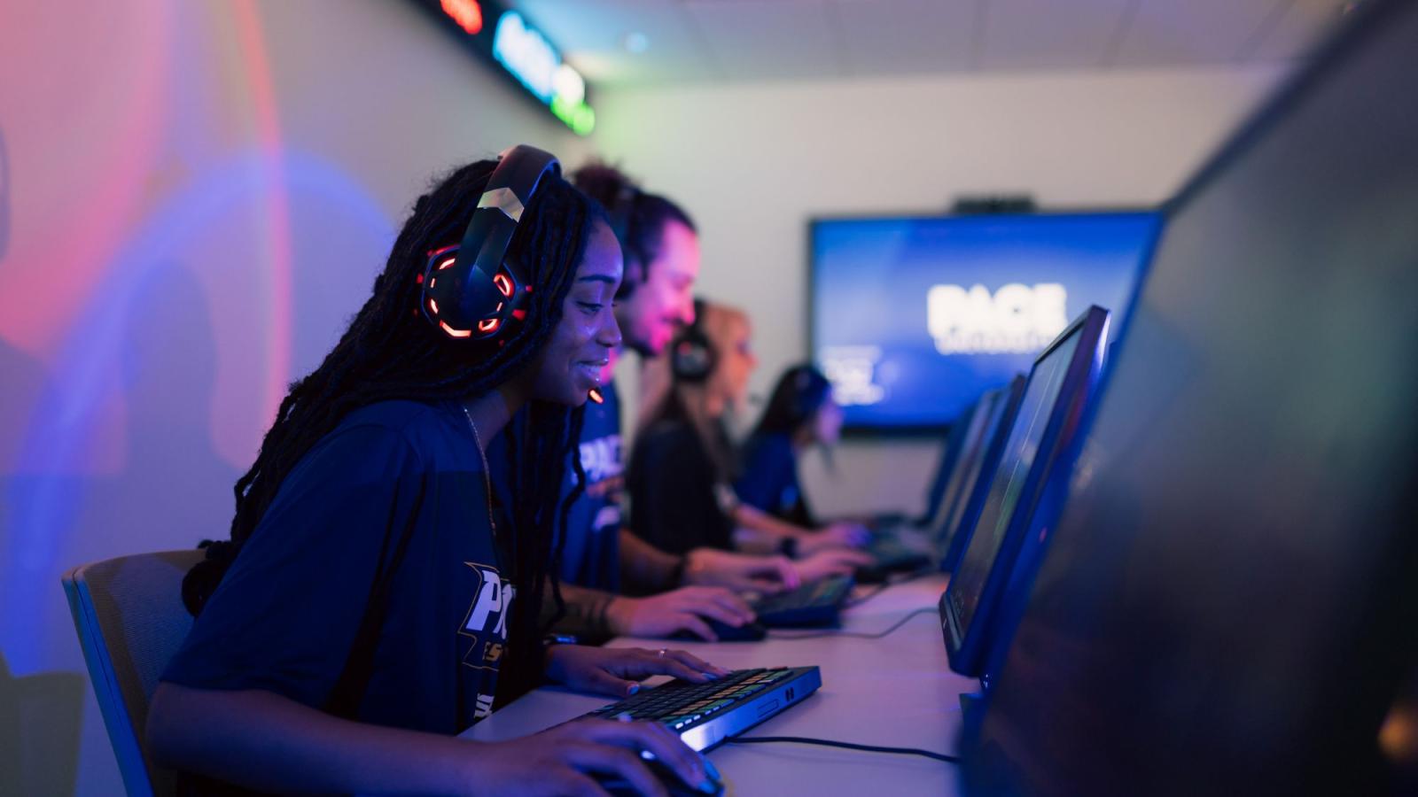 A student sits at a computer with a headset on.