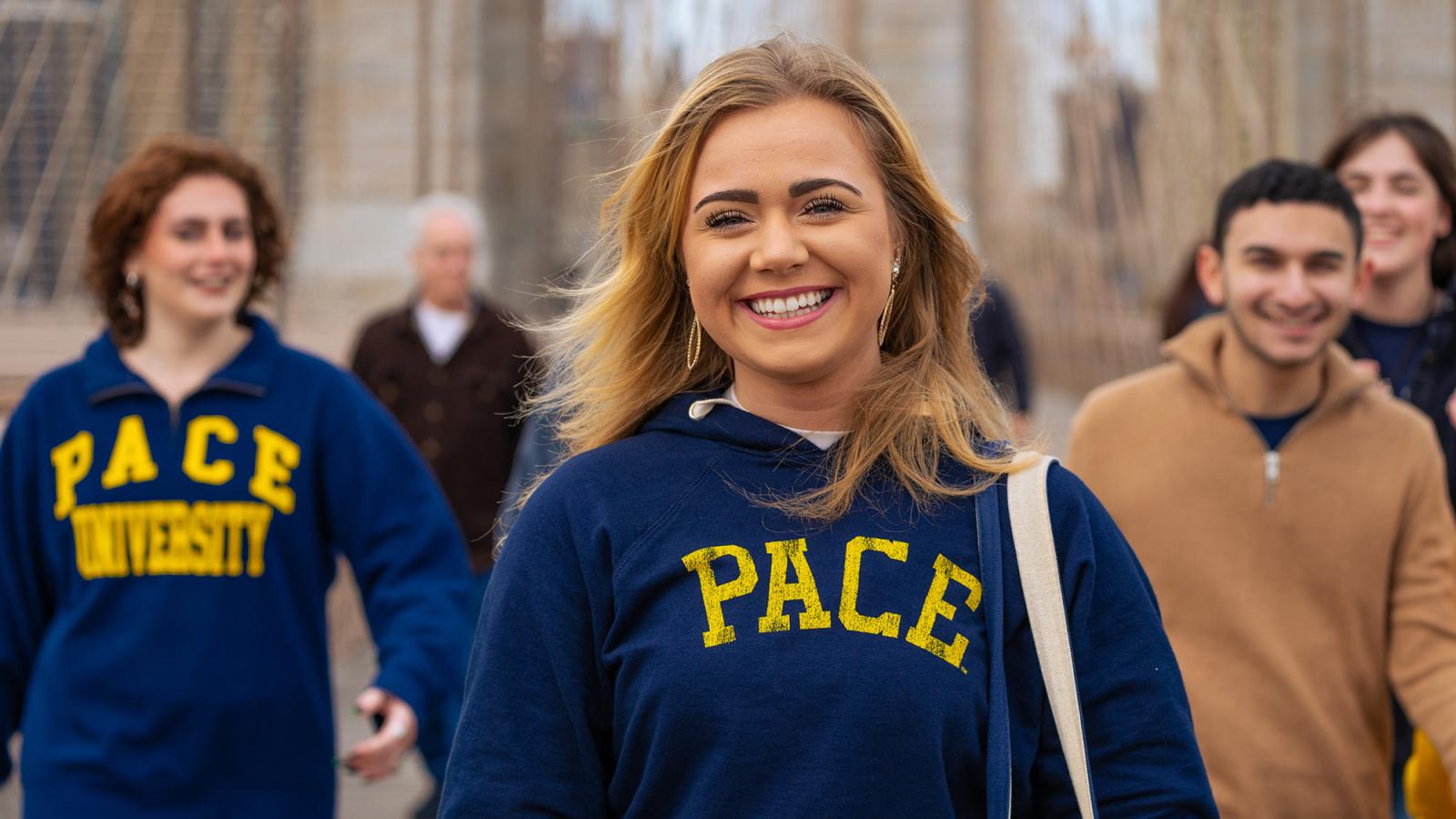 a Pace student leads others as they walk across the Brooklyn bridge