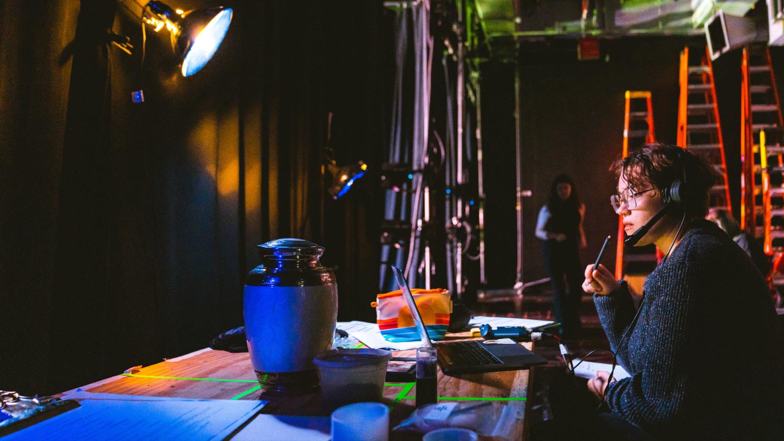 production student sitting at a table backstage