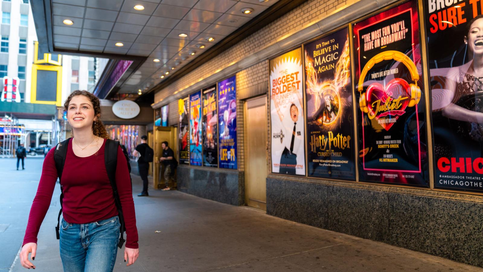 Sands College of Performing Arts student, Skye Alyssa Friedman walking near Broadway show posters.