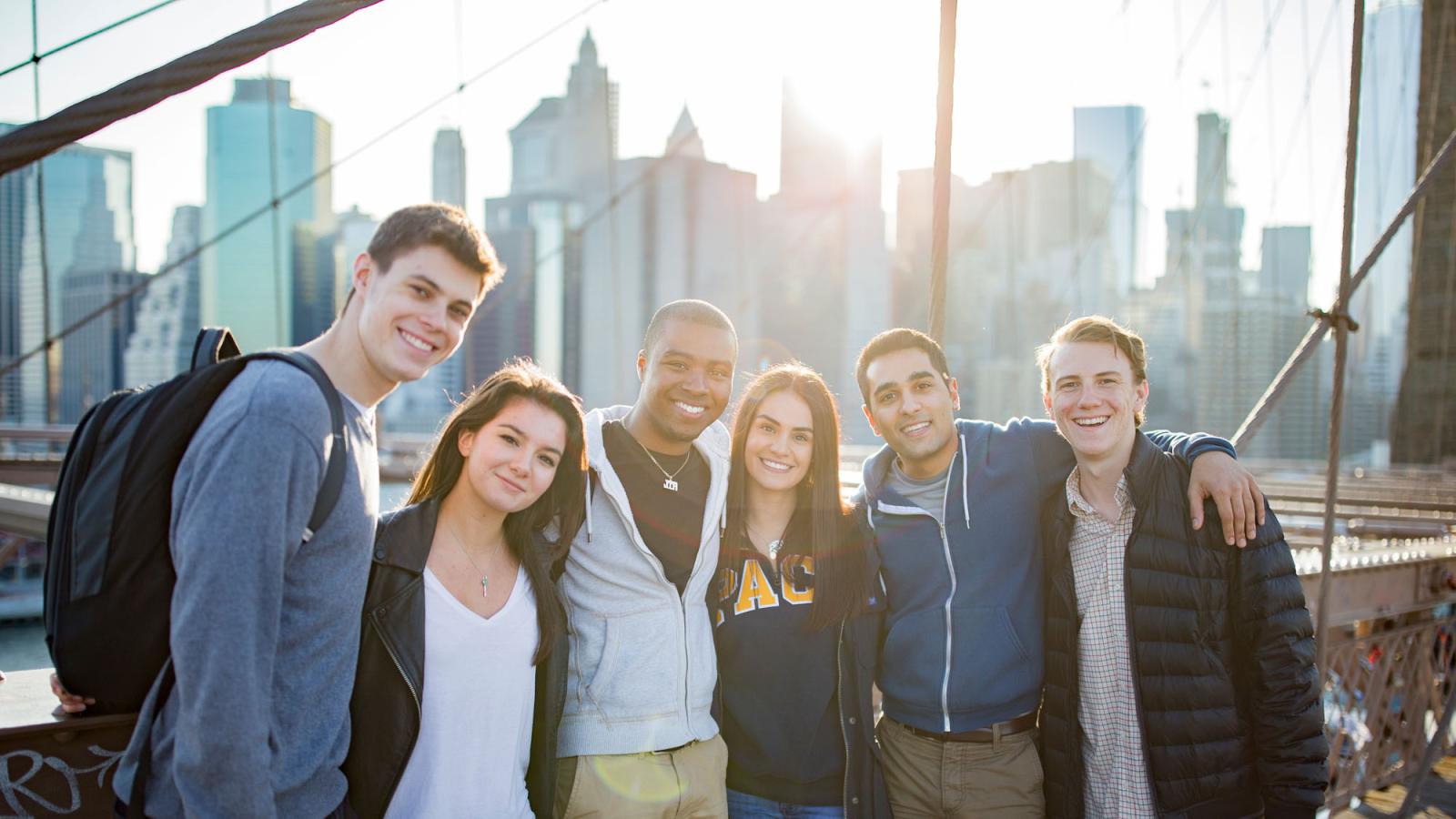 Pace University Lubin Students standing on the Brooklyn Bridge in front of the New York City skyline