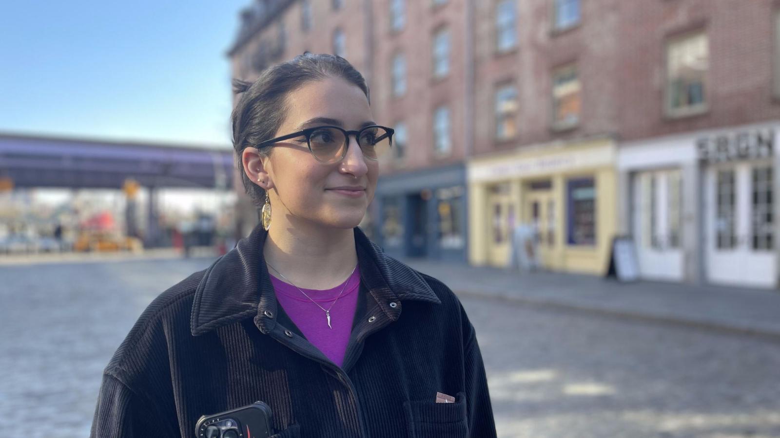 Pace Student Lauren DeMaio standing in front of old buildings in Seaport, NYC.