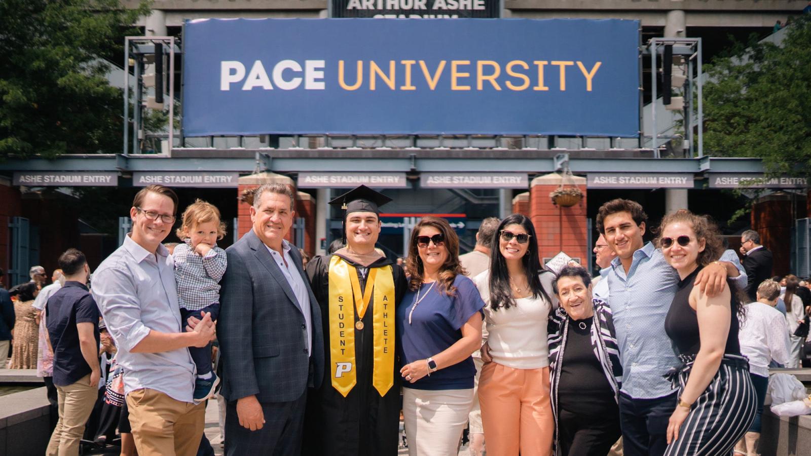 Pace graduate and family posing at Commencement