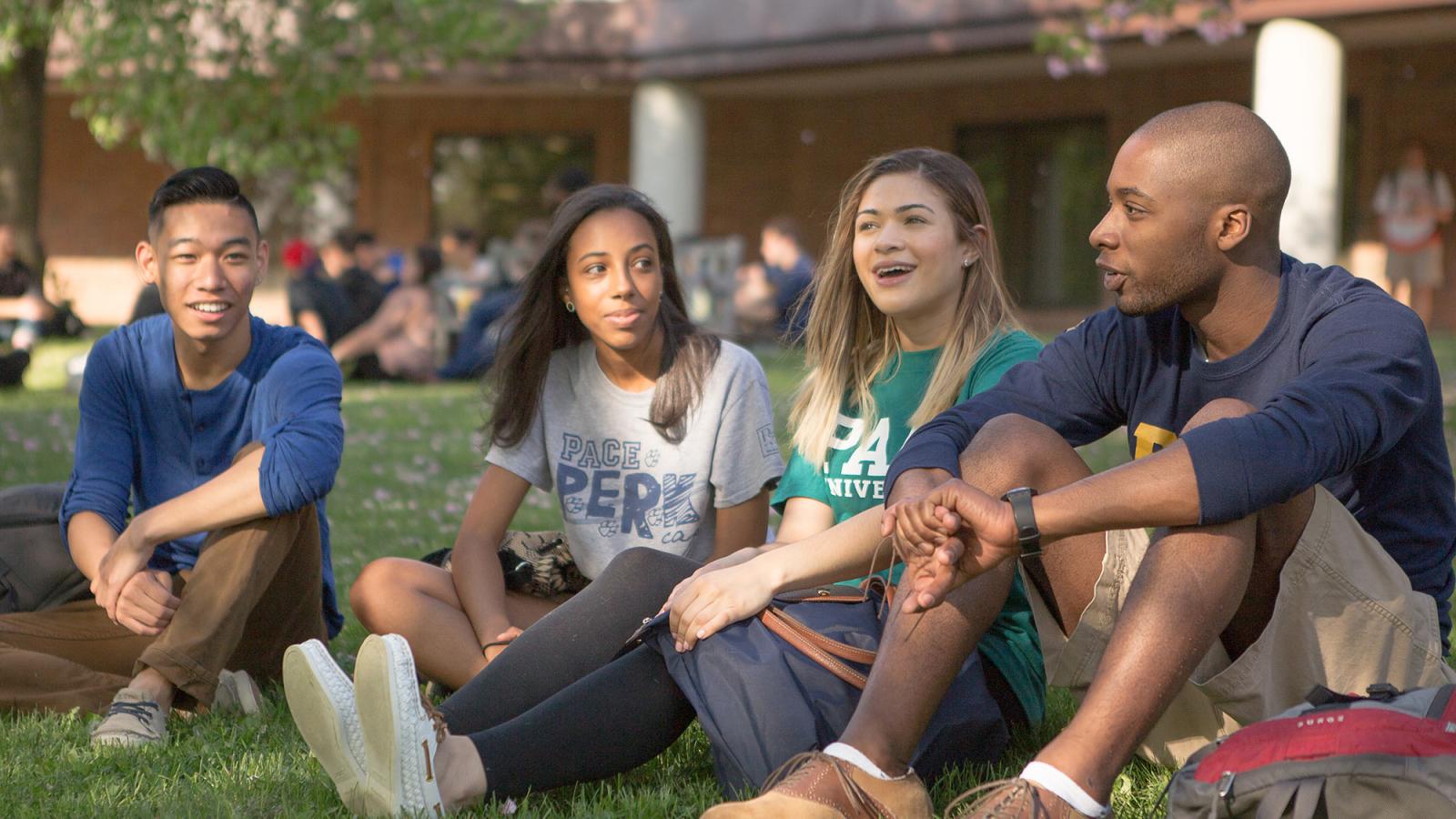 Pace students sitting in the grass, in front of Mortola Library on the Pleasantville campus