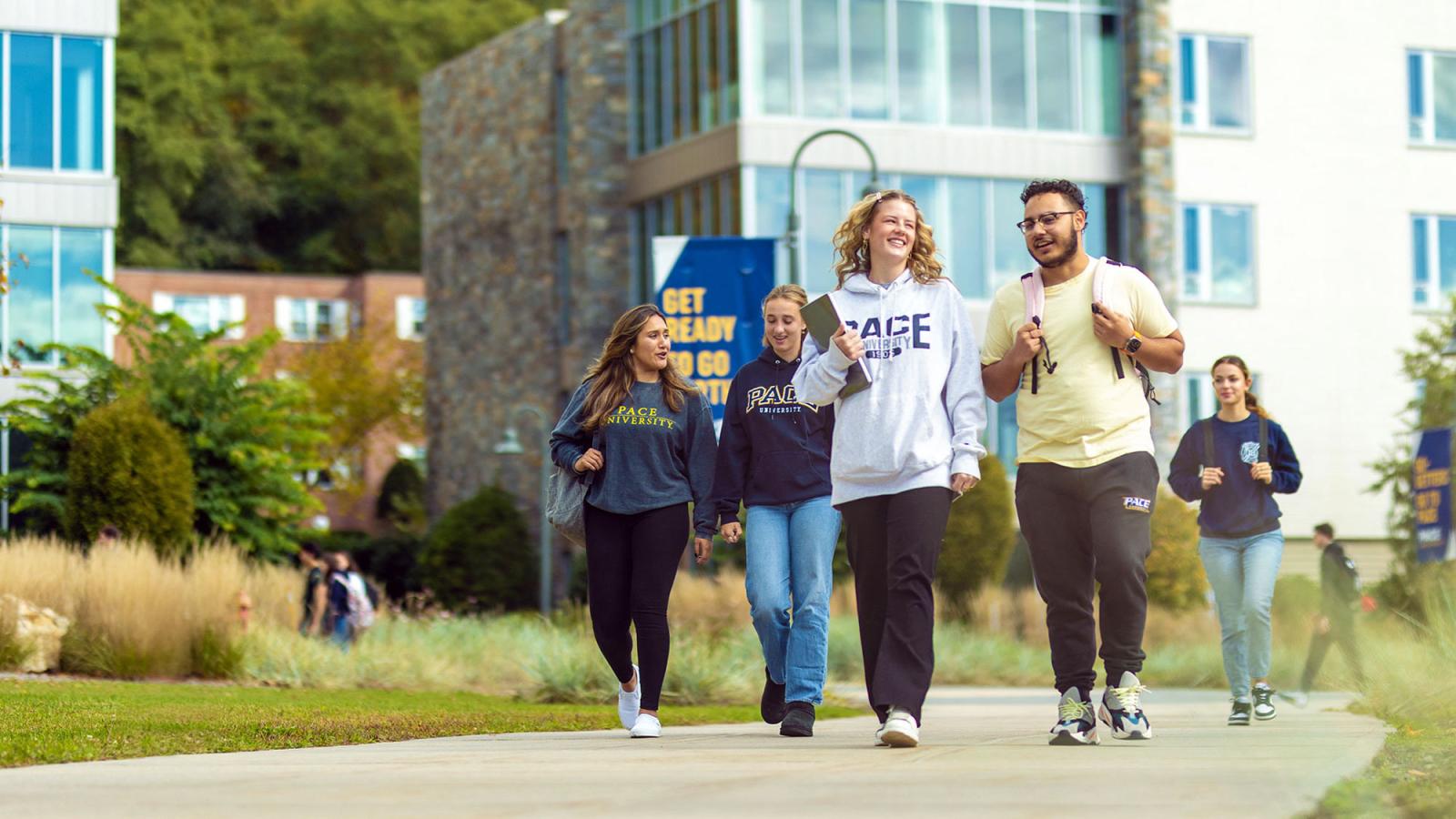 Group of Pace University students walking across the Pleasantville campus talking and smiling