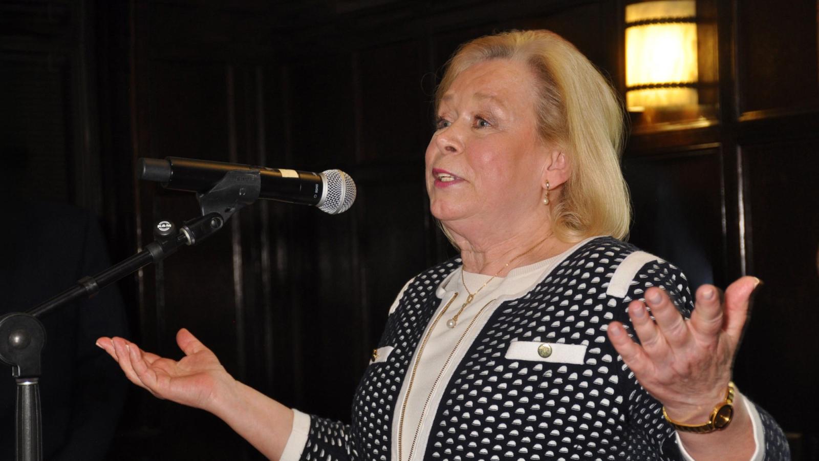 Barbara Farrell speaking into a microphone.