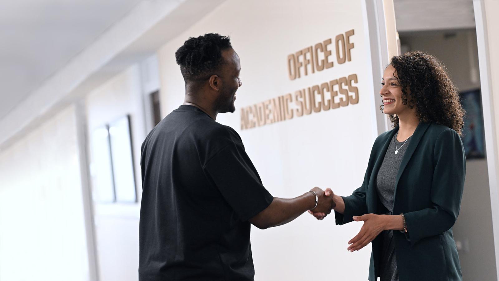 Counselor shaking hands with a student at the Elisabeth Haub School of Law Office of Academic Success