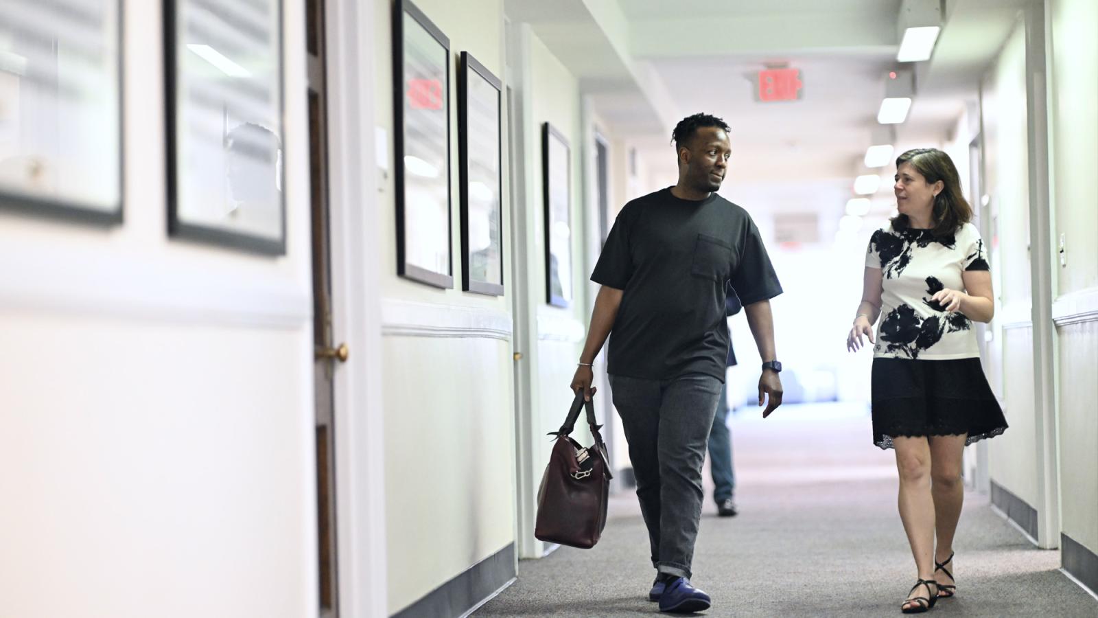 A student and professor from the Elisabeth Haub School of law, walking down a hallway.
