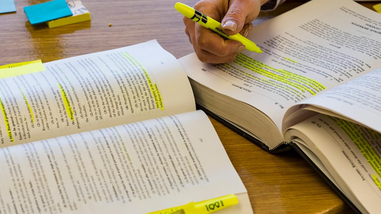 Open books and student highlighting books