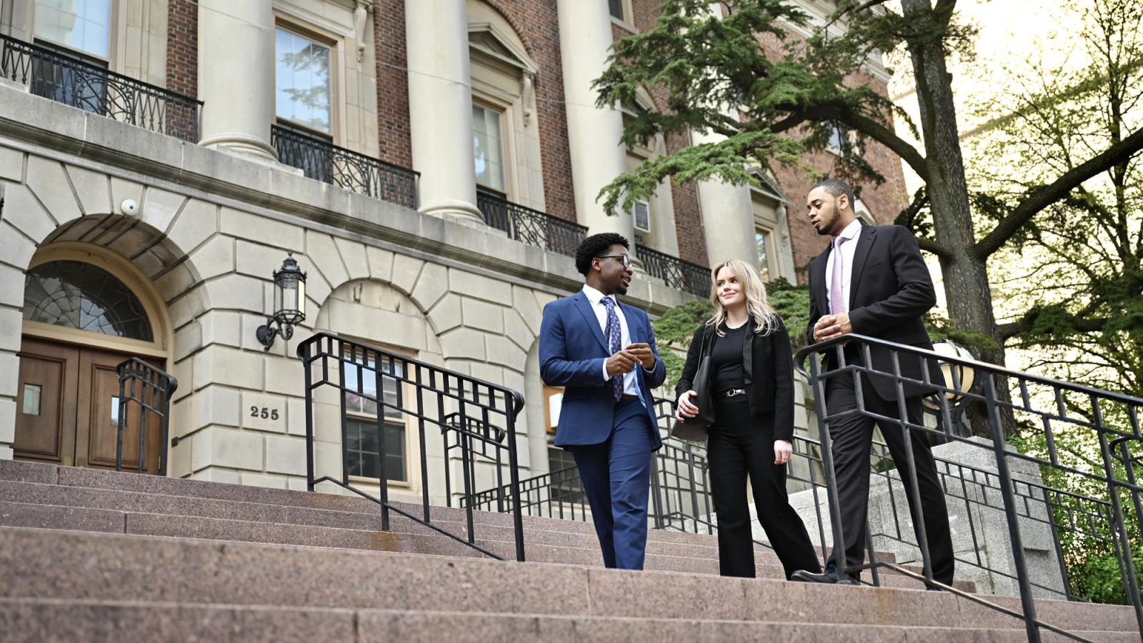 Three Elisabeth Haub School of Law students walking on steps on campus