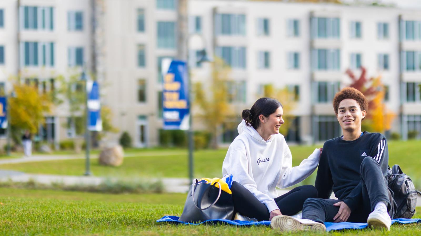 Pace students sitting on the lawn of the Pleasantville Campus.