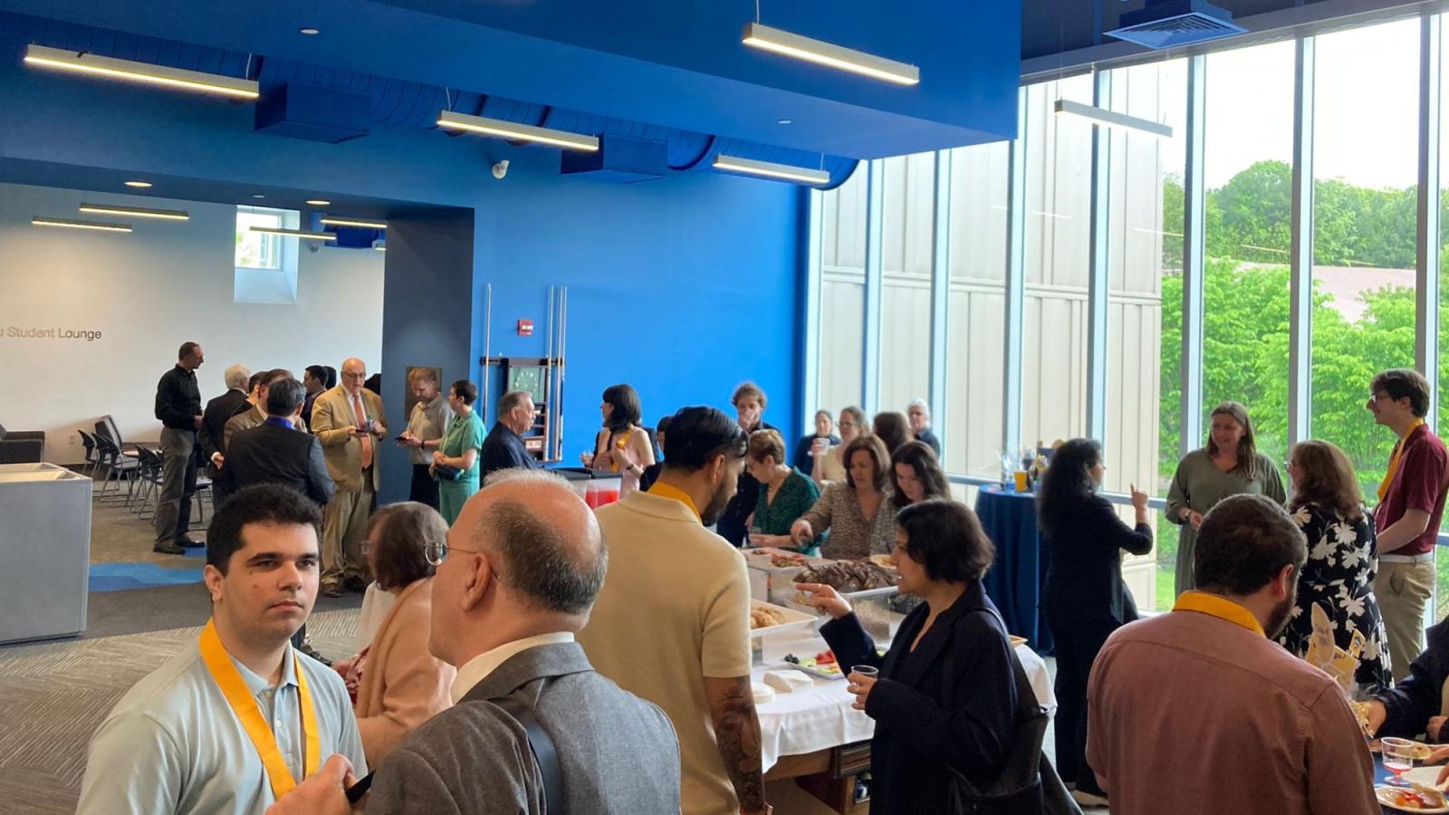 Seidenberg students, faculty, staff, and families spread around a lounge at Pace University's Pleasantville campus, talking to each other in a party setting.