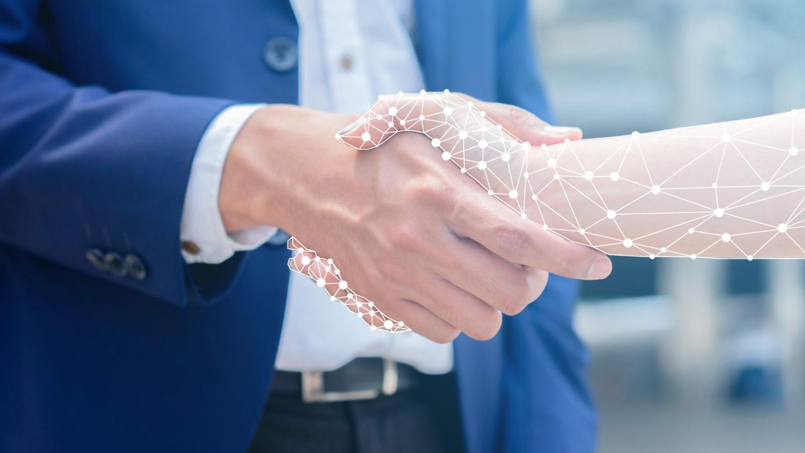 A man in a suit shaking hands with a cybernetic arm.