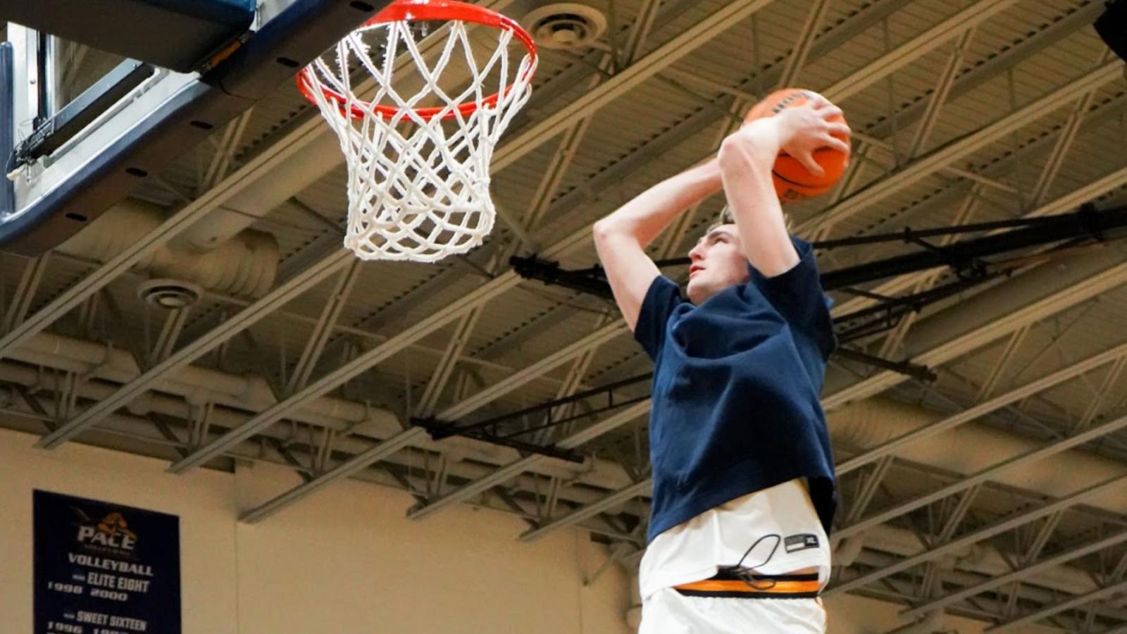 Pace University Seidenberg student Justin O'Neill dunking a basketball into a hoop at the Pace gym during a basketball game.