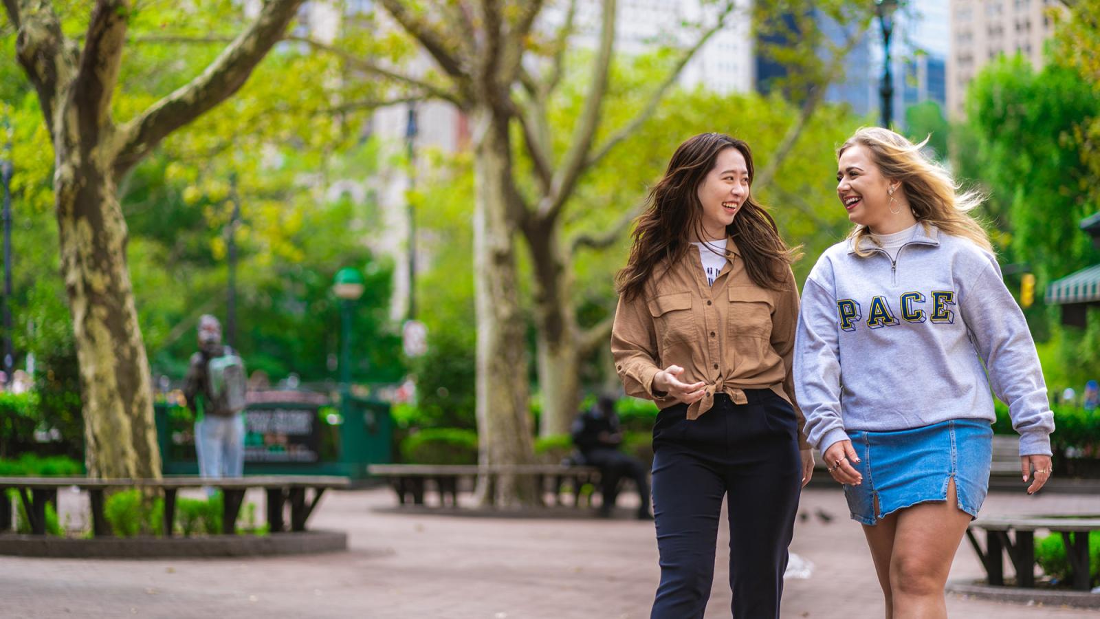 Two Pace University students walk through a New York City park