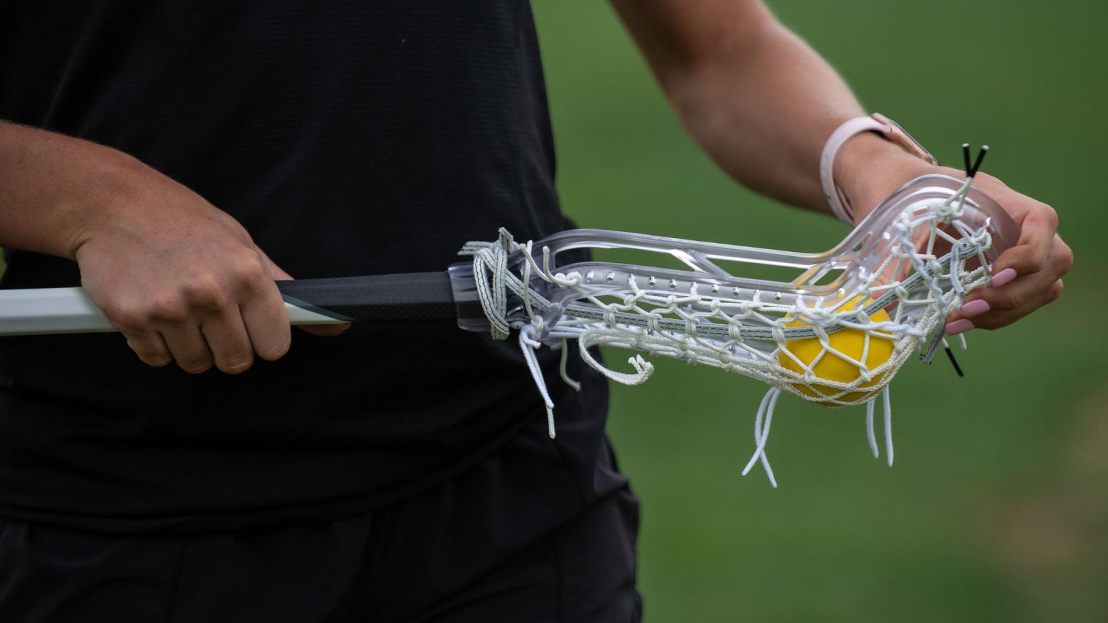 Woman holding a lacrosse stick.