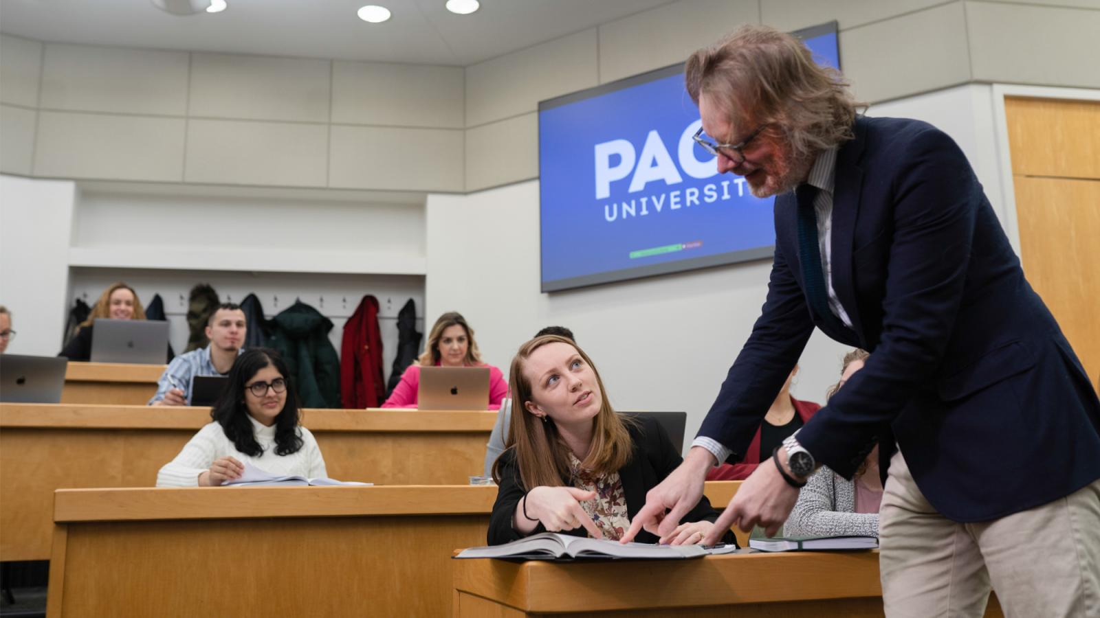 A faculty member working with students in a Haub Law classroom.