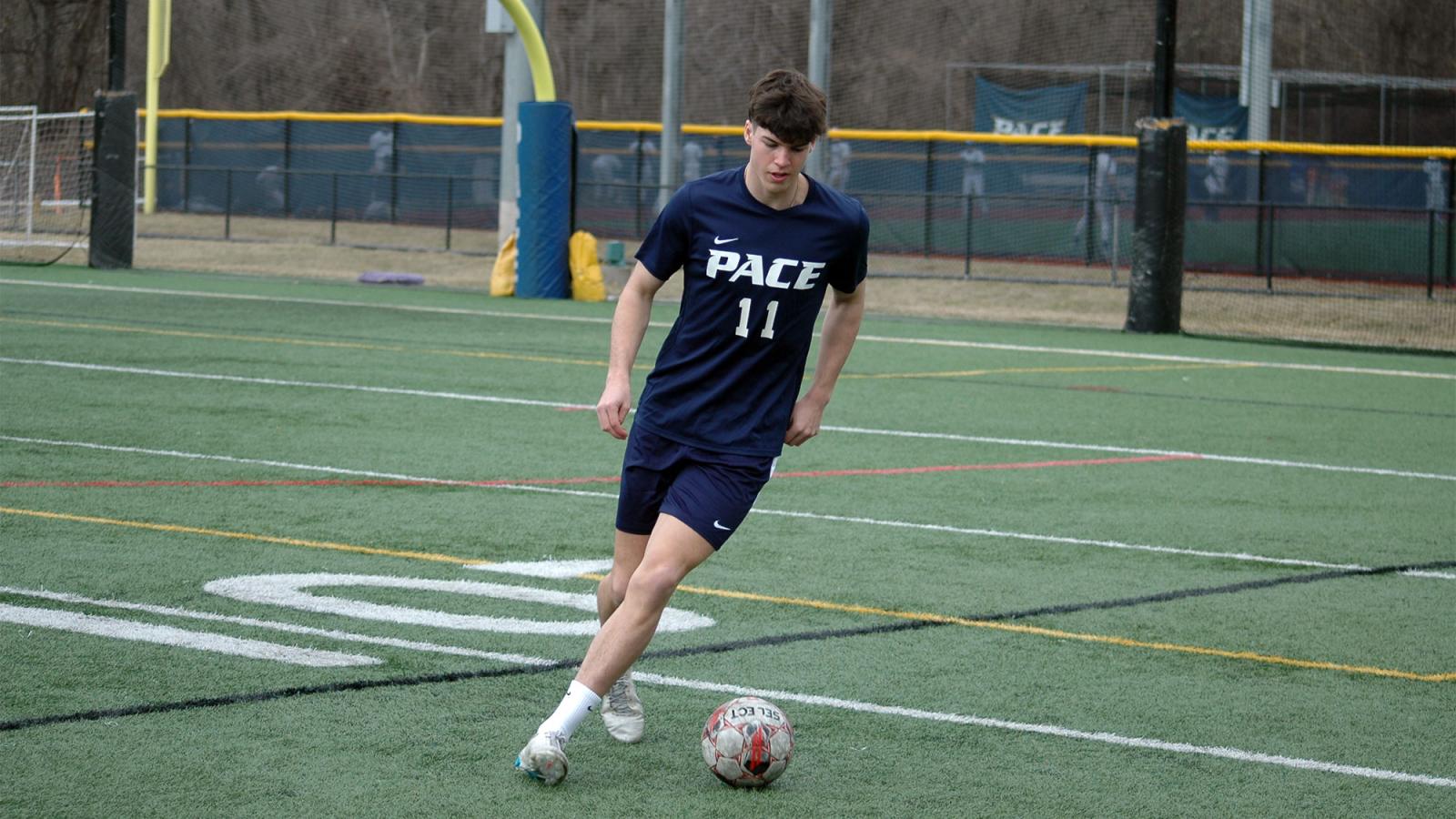 Pace student kicking a soccer ball.