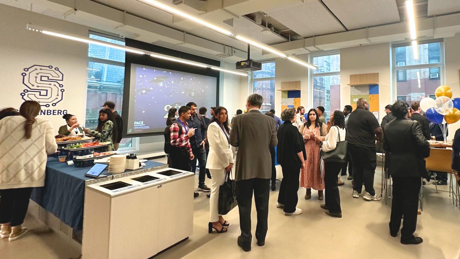 Seidenberg students, faculty, staff, and the students' families mingling in Seidenberg's Design Factory space.
