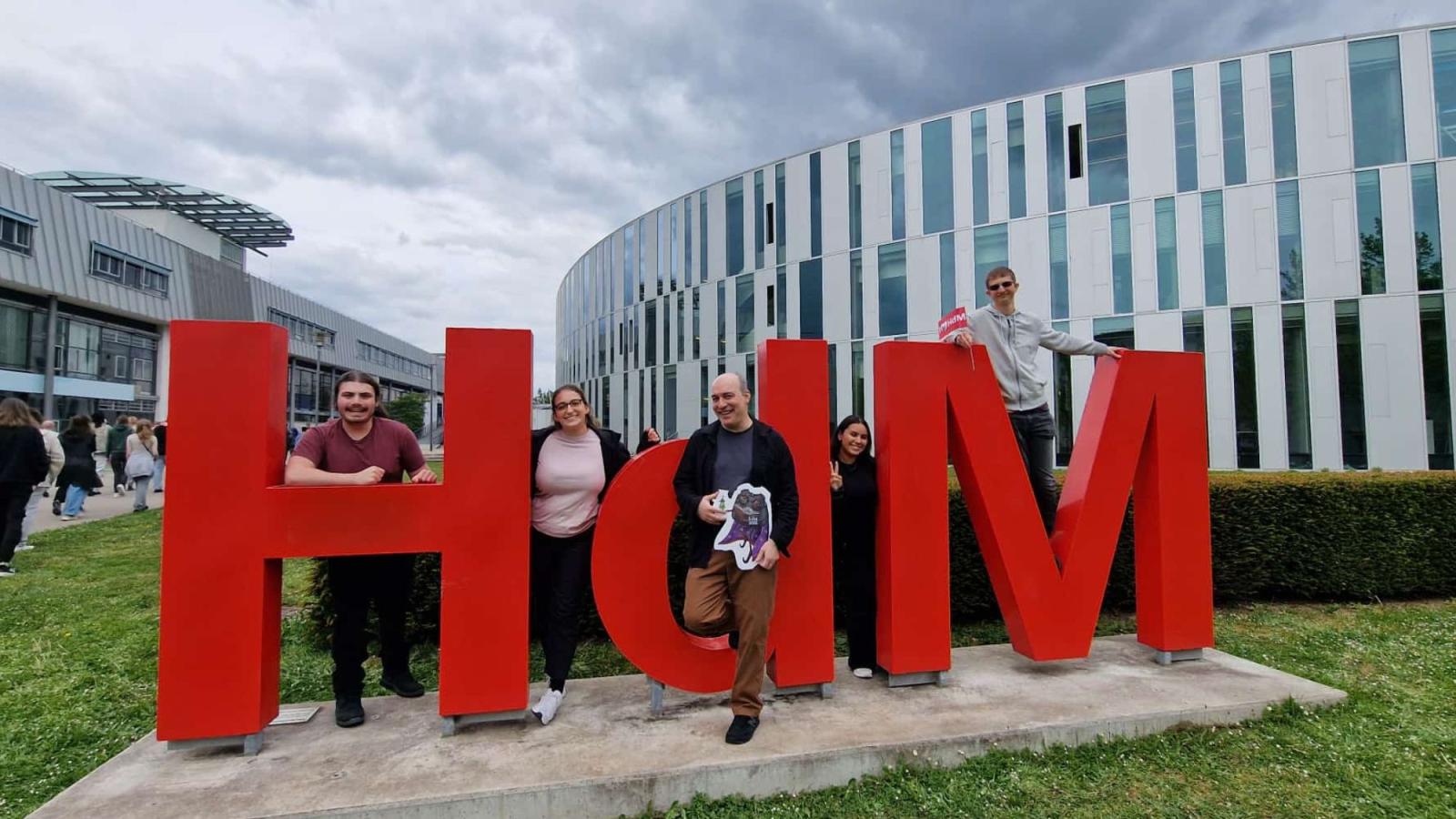 Pace Seidenberg professor Carmine Guida and a group of Seidenberg students posing for a photo in front of the FMX educational fair in Stuttgart, Germany.