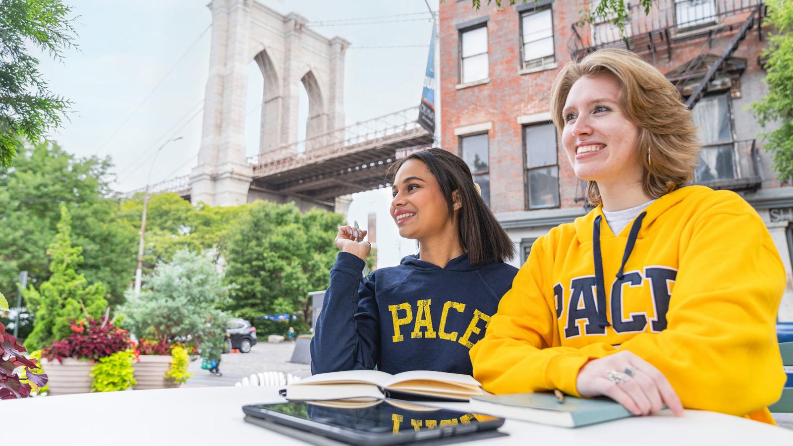 Two Pace University students sitting at a cafe under the Brooklyn Bridge in Manhattan.