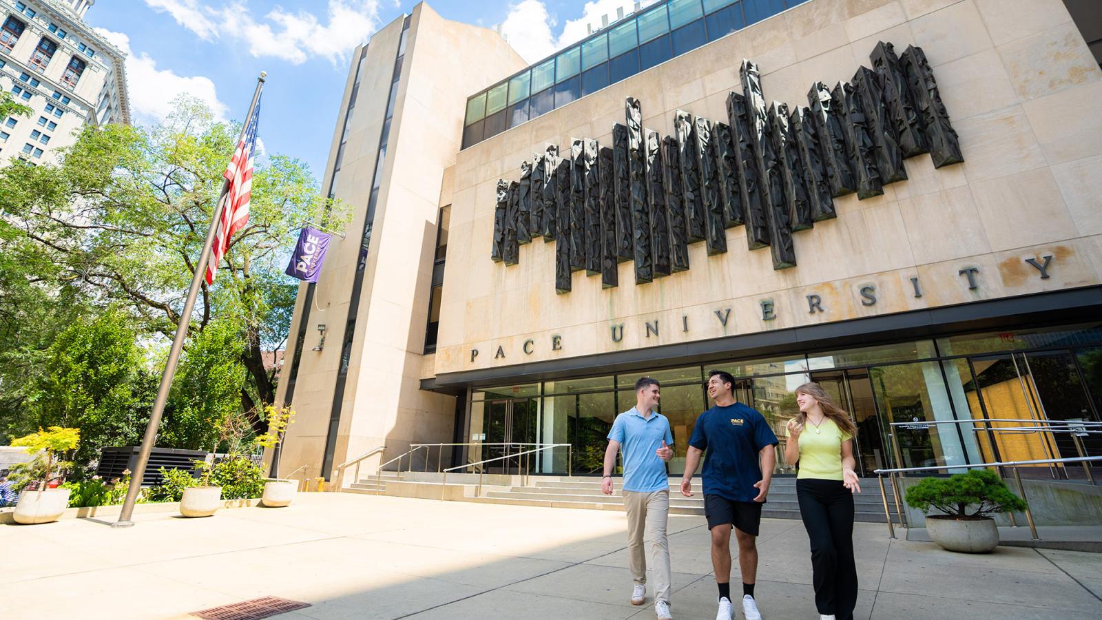 Three students walking in front of One Pace Plaza on the New York City campus of Pace University.