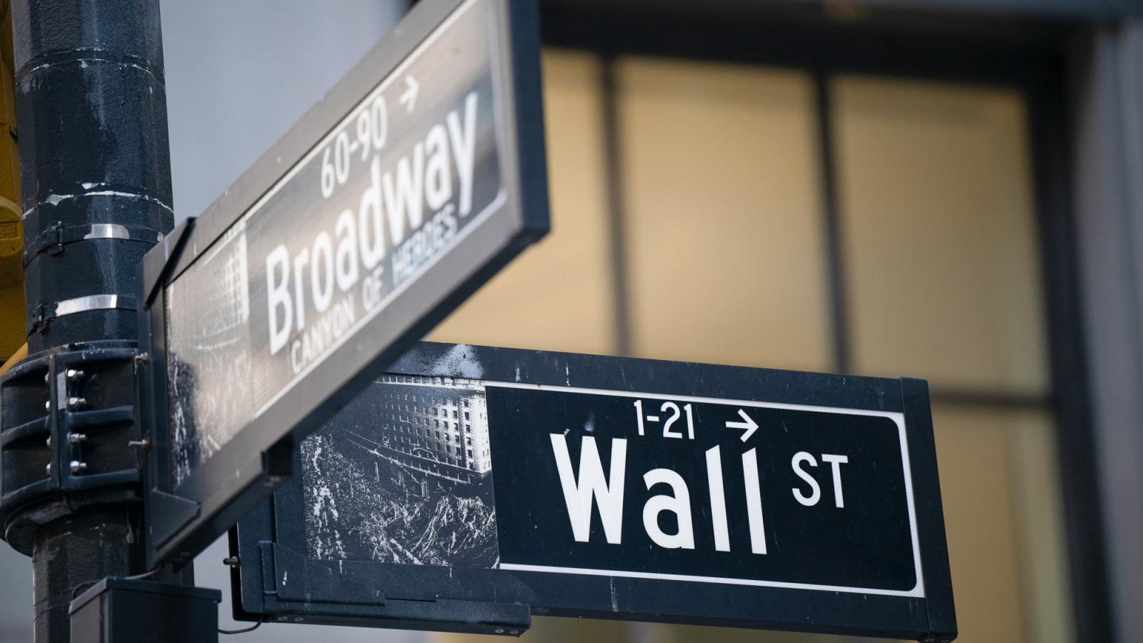 Street signs marking the intersection of Wall Street and Broadway in New York City’s Financial District