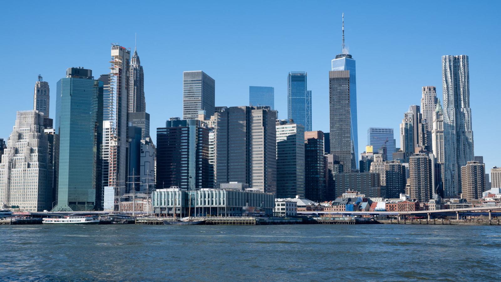 Panoramic view of the Lower Manhattan skyline, featuring One World Trade Center rising above New York City’s Financial District