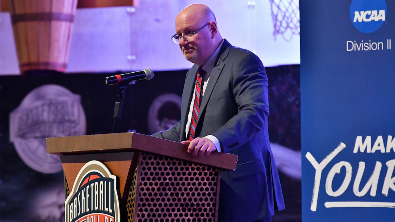 Pace University Athletics director Mark Brown delivers a speech at a podium 