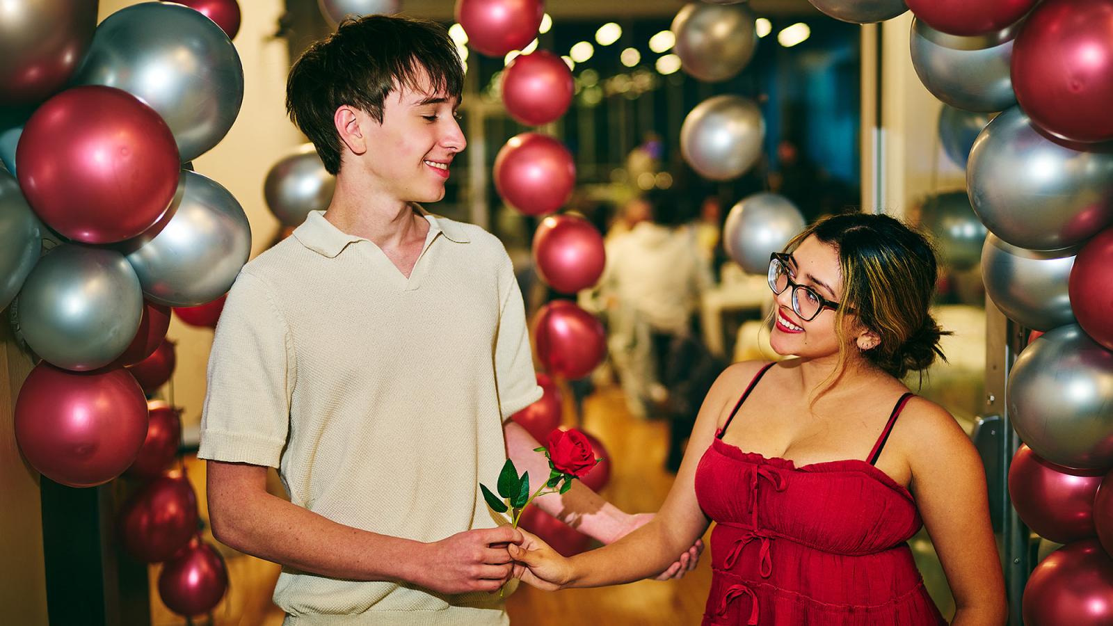 Two Pace University students smile at each other at a campus date night