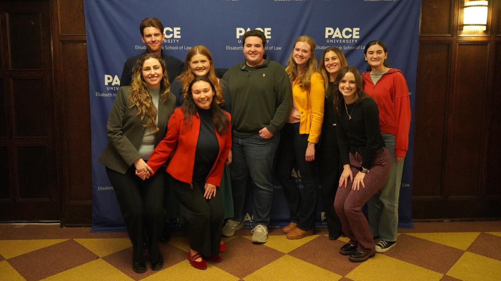 Elisabeth Haub School of Law at Pace University students standing in front of Pace banner