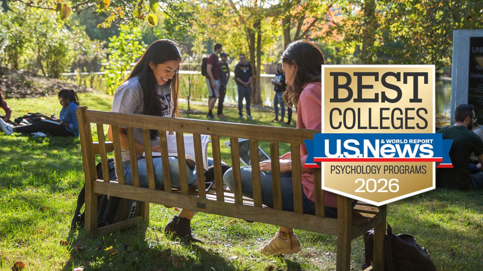 Two Pace students sitting on a bench in conversation on the Pleasantville Campus. 