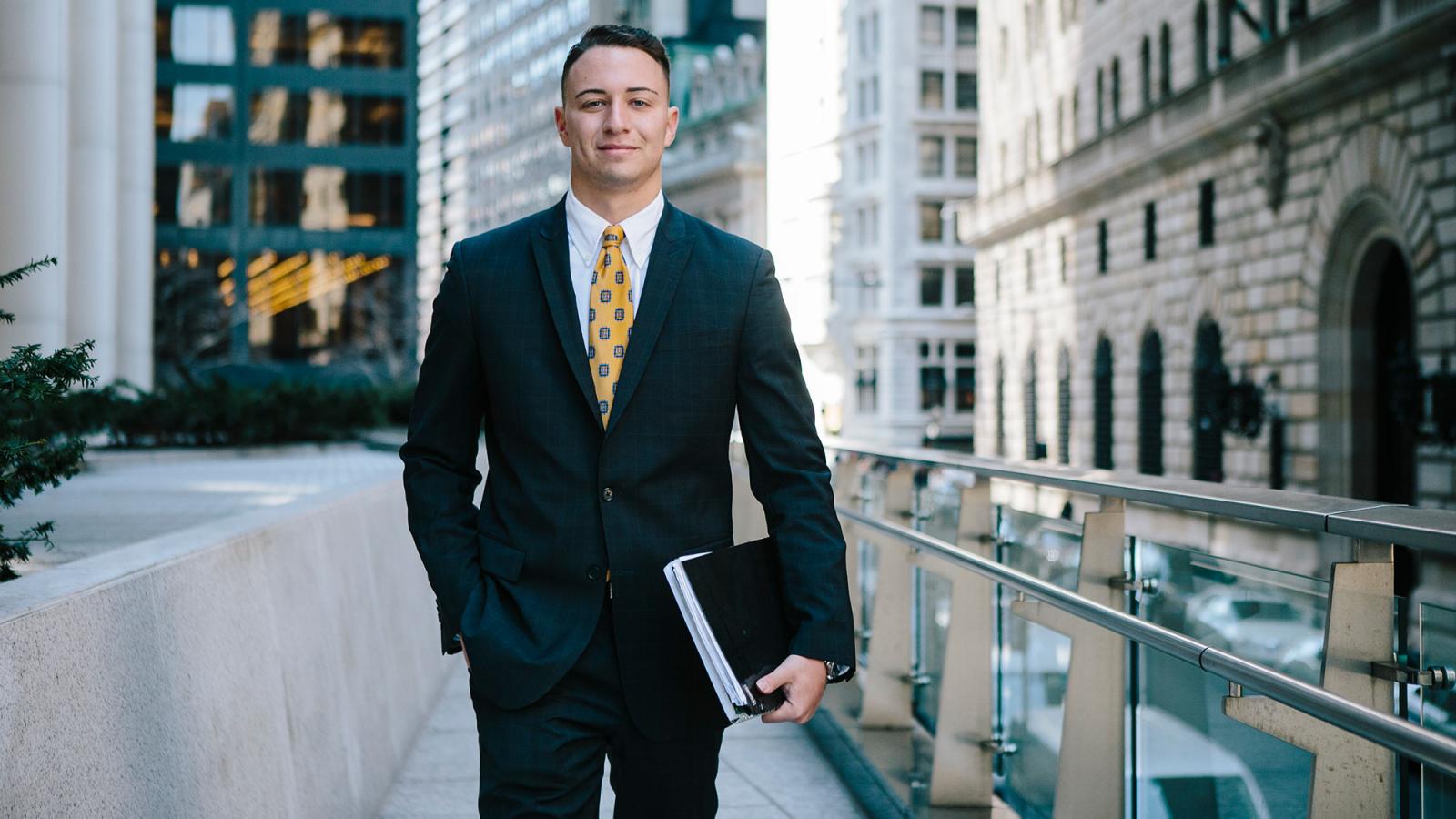 Lubin student in business attire standing in Lower Manhattan's Financial District