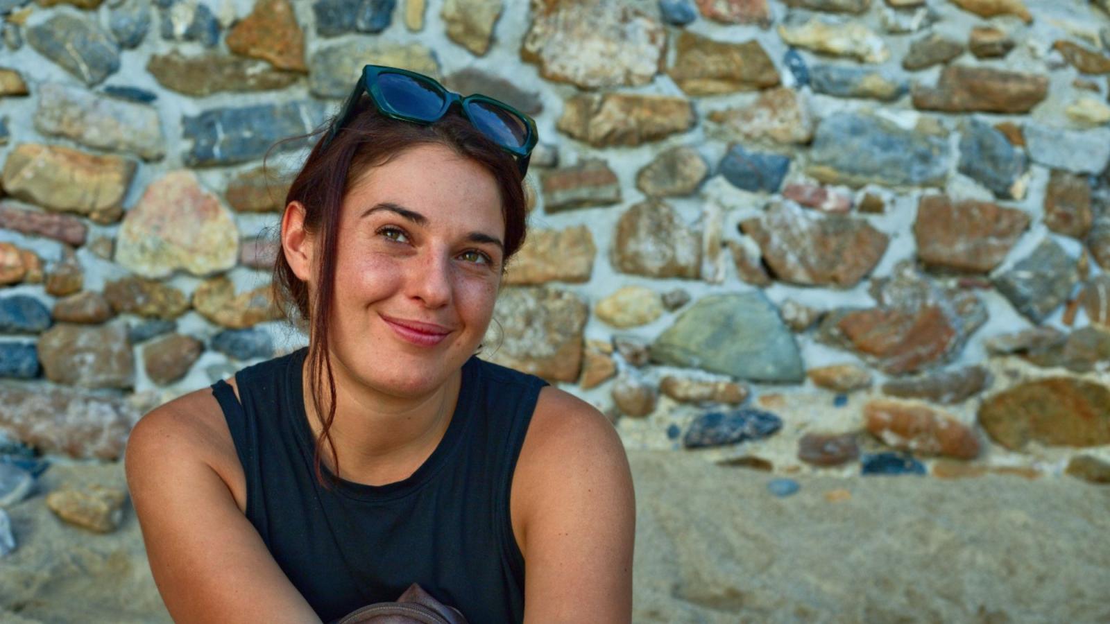 Seidenberg professor Sara Falcone posing for a photo in front of a rocky background.