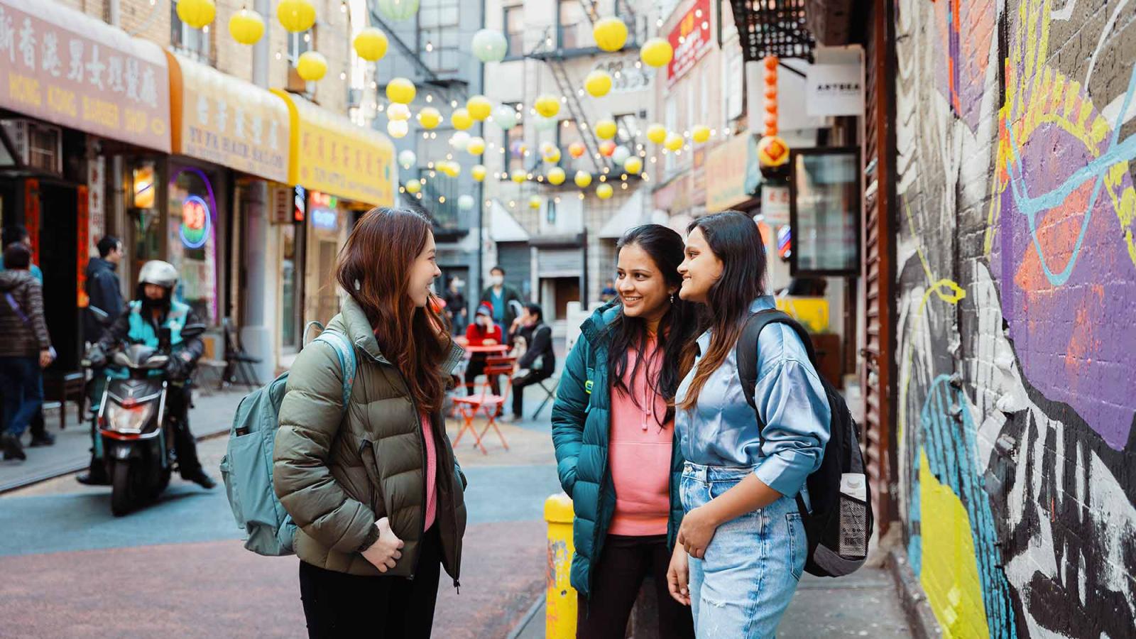 Pace University students socialize in a colorful street in Chinatown.