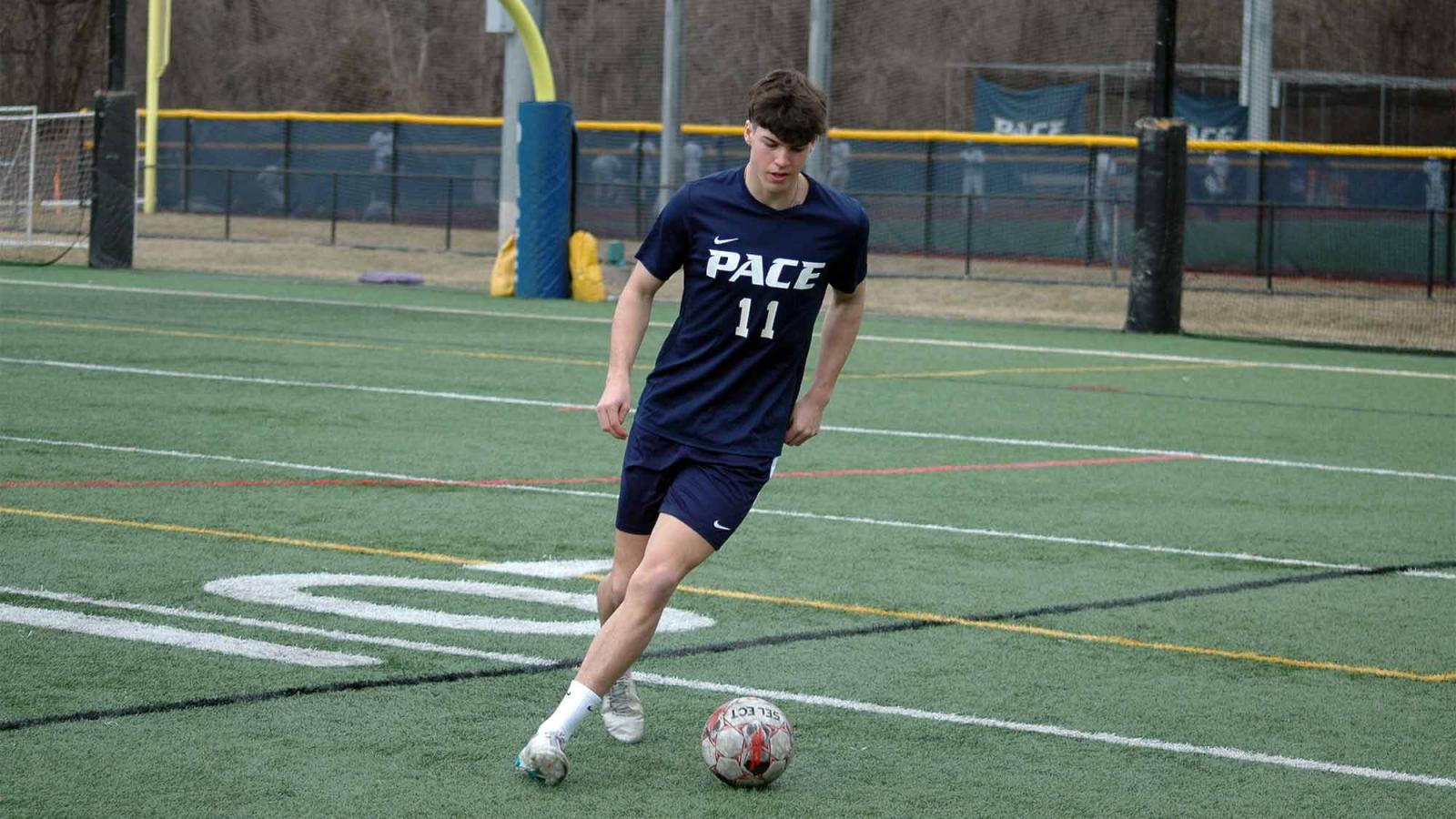 Pace student kicking a soccer ball.