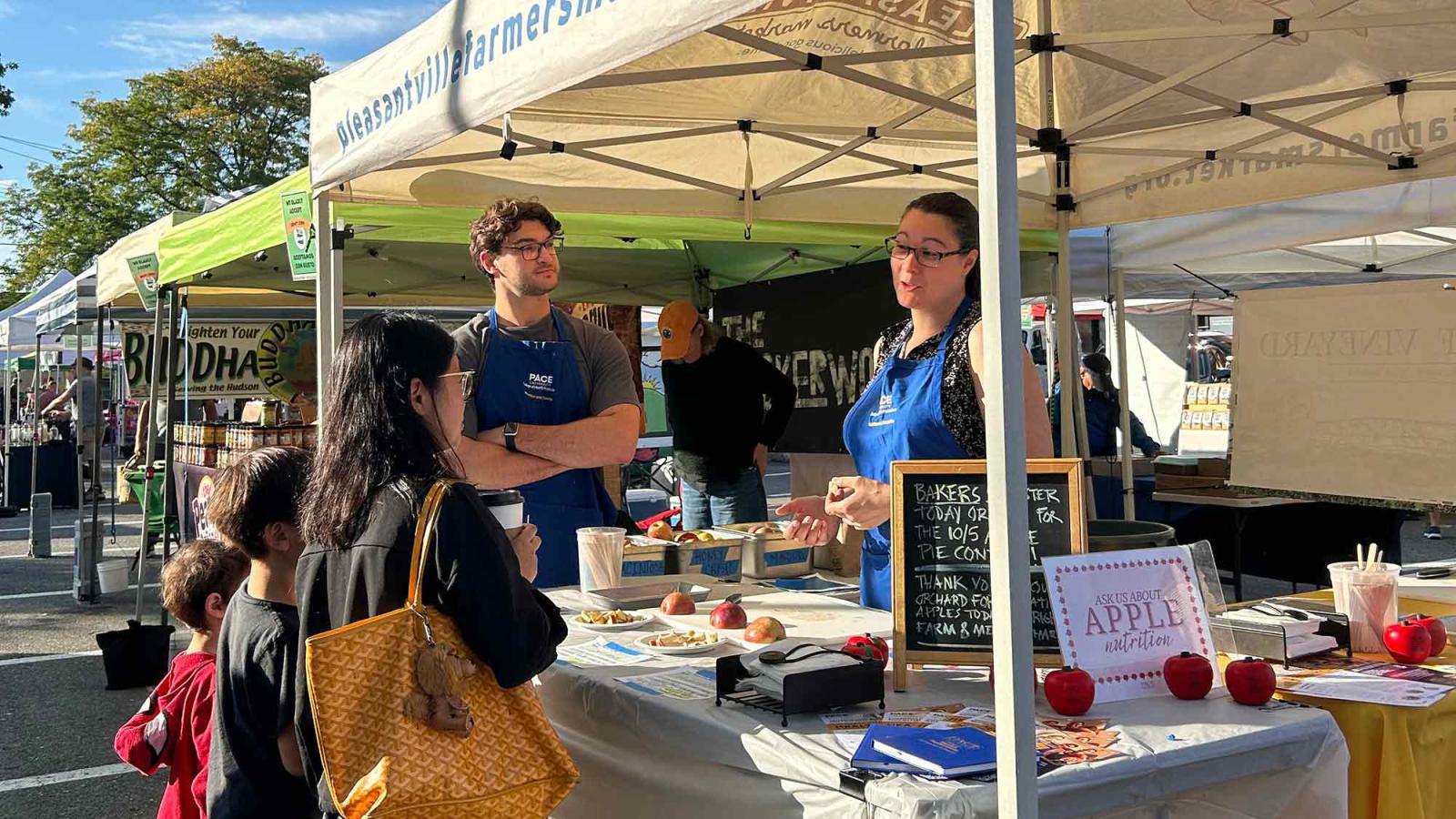 Shoppers and vendors talking at the Pleasantville Farmers Market
