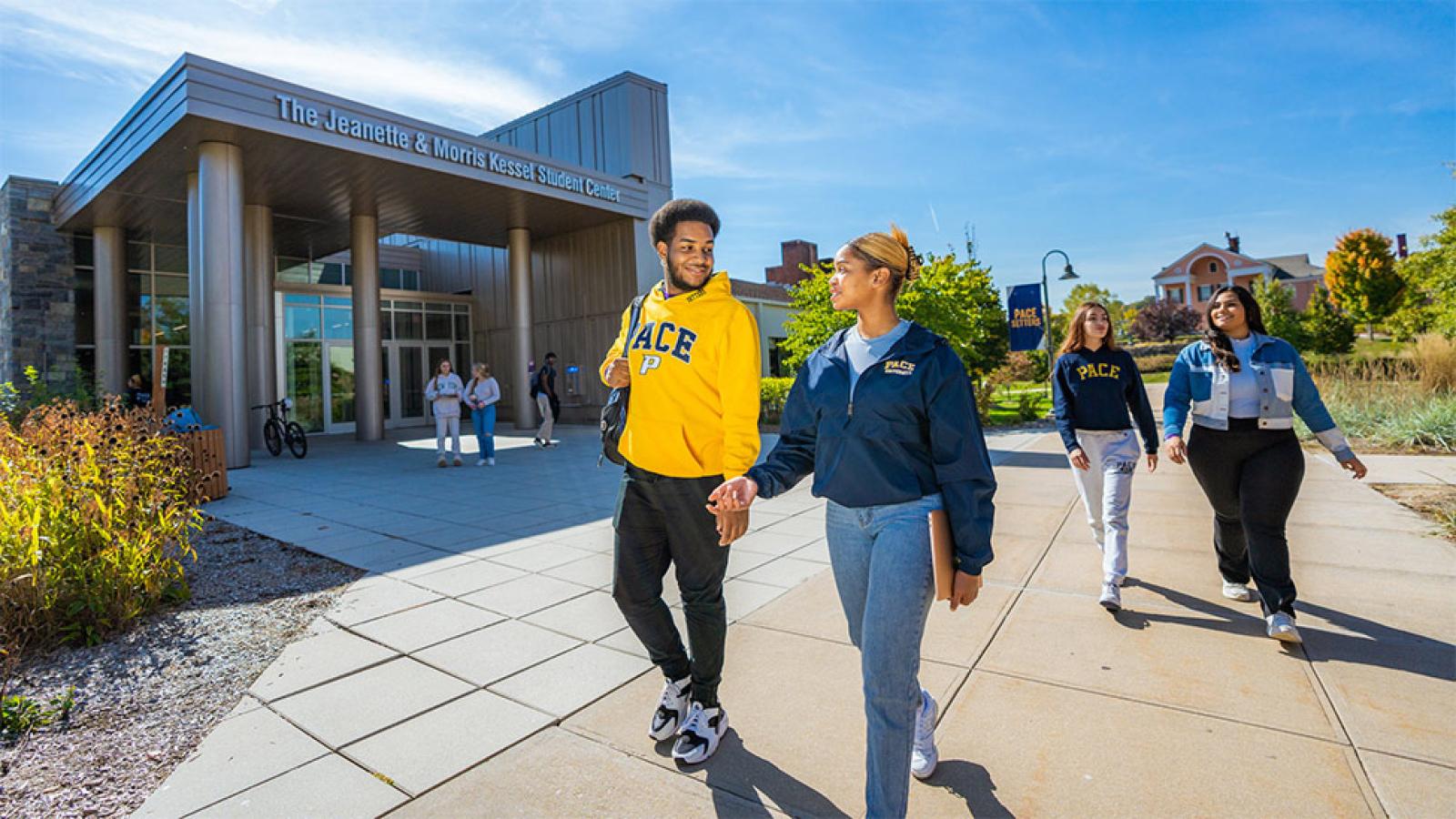 Two Pace University students walking in front of the Kessel Student Center on the Pleasantville, NY campus.